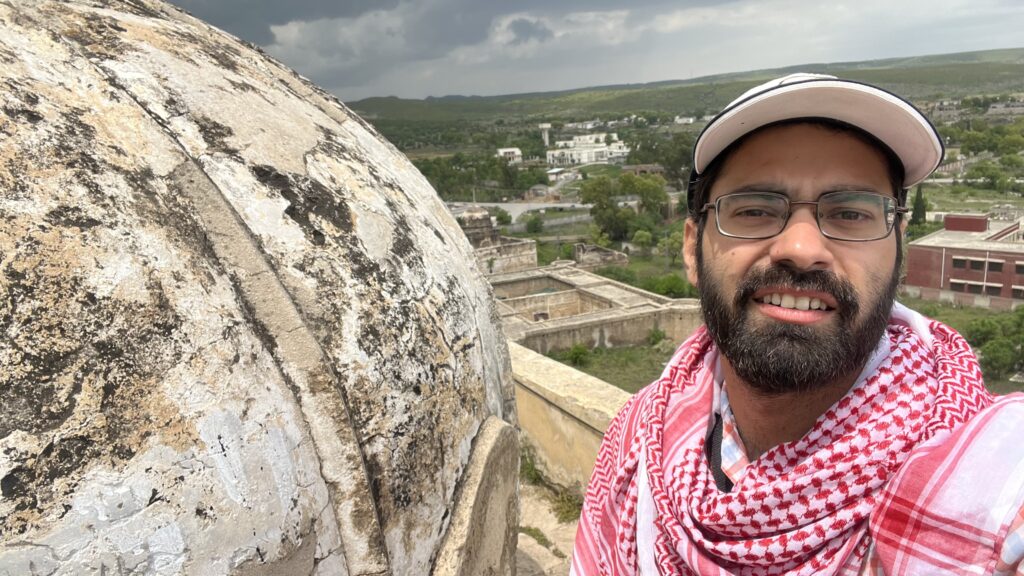 A selfie taken from the roof of the main Katas Raj temple, capturing the temple dome up close with the green valley stretching beyond