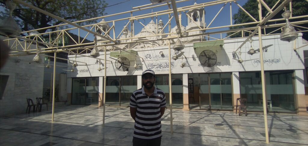 Interior view of Masjid Sardar Mozang with stained glass entrance and white courtyard